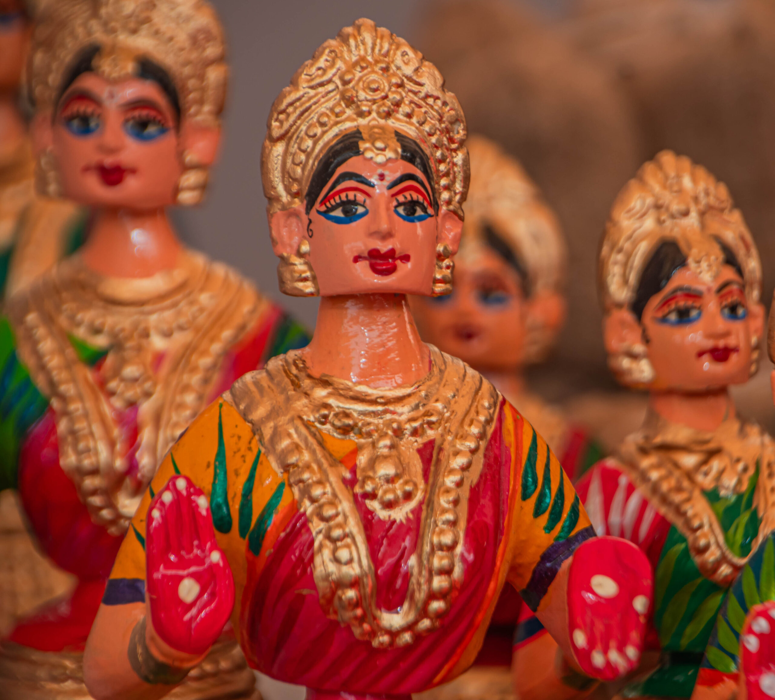Close-up of colorful Kondapalli wooden dolls with detailed facial expressions and traditional attire.