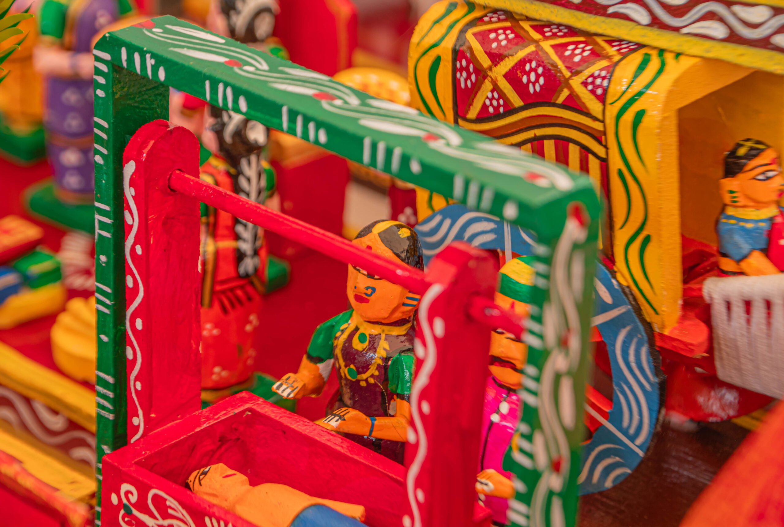 Miniature wooden village scene with figures and colorful structures.