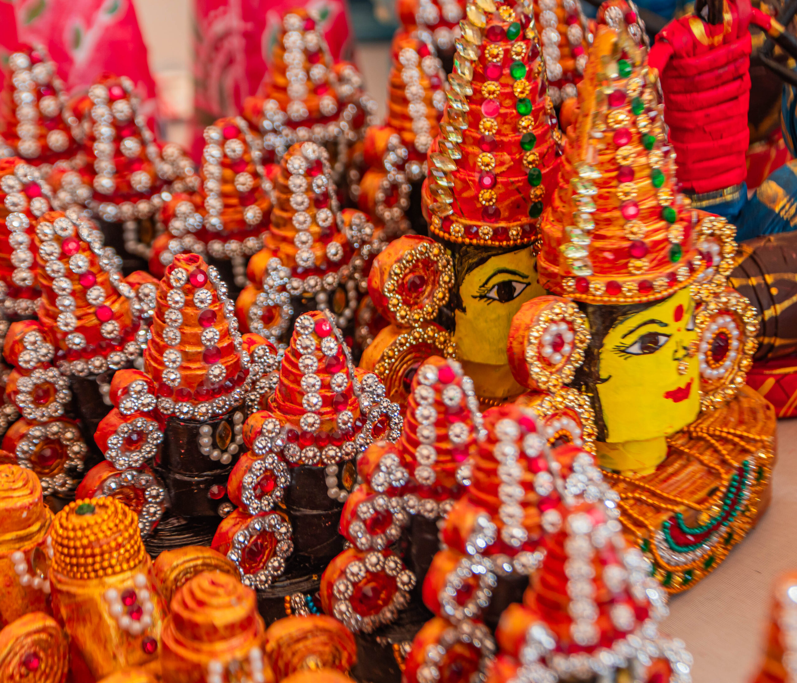 Collection of brightly decorated handcrafted figurines with beads and ornaments.