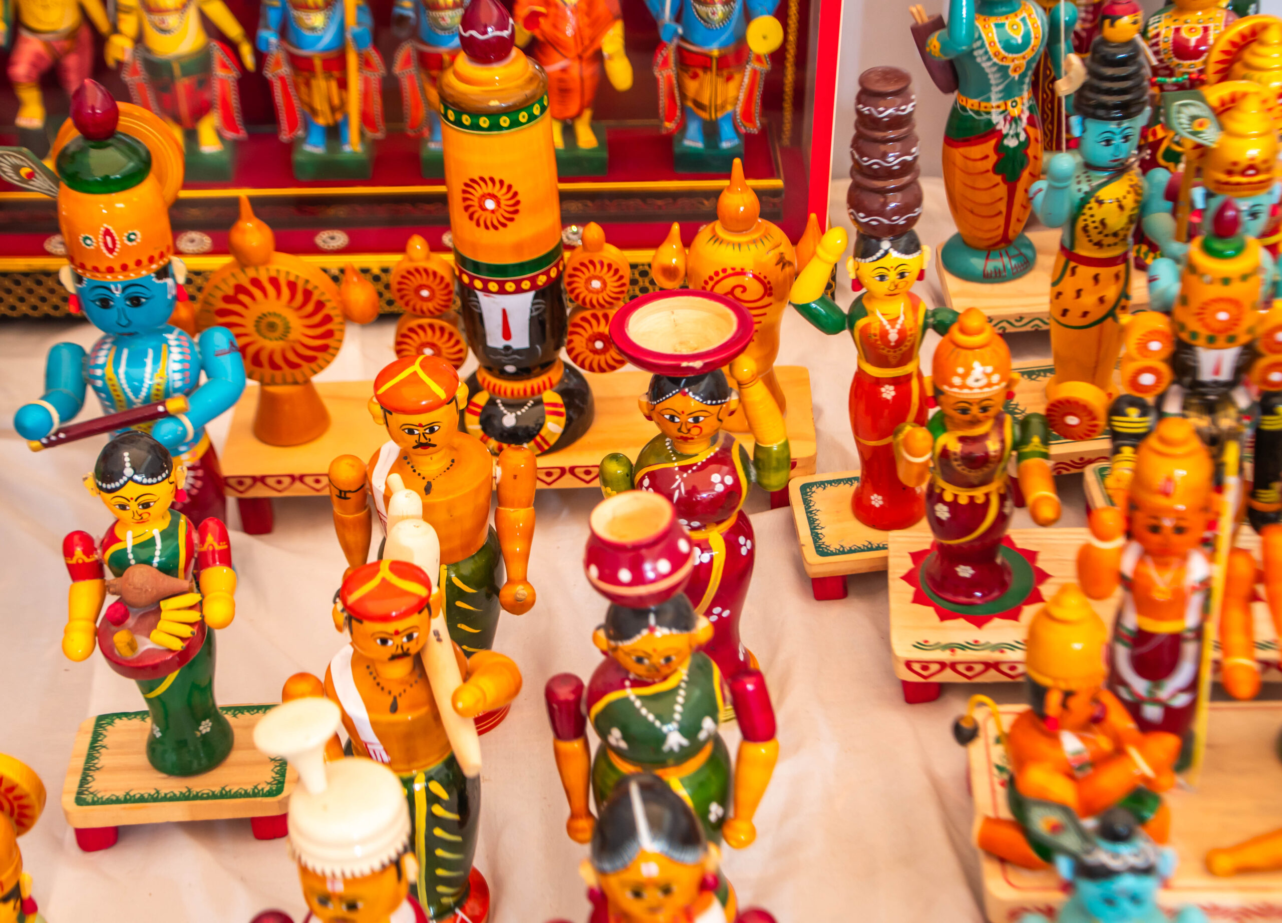 Display of colorful Kondapalli toys including human figures and cultural elements.